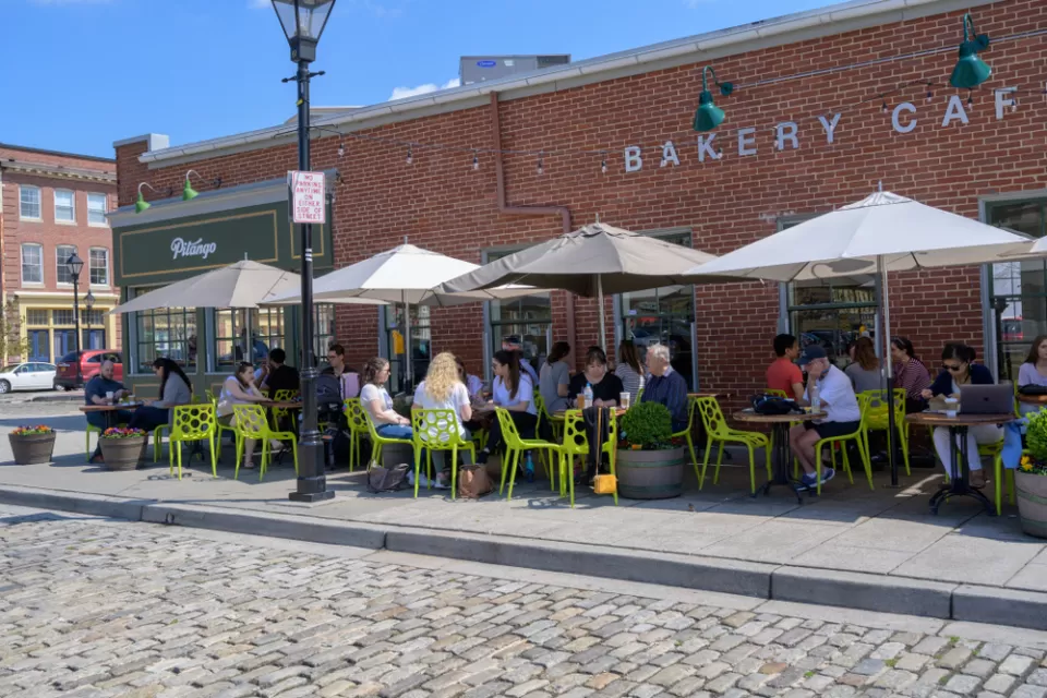 Outdoor dining with bright green chairs on a sidewalk in Baltimore, Maryland
